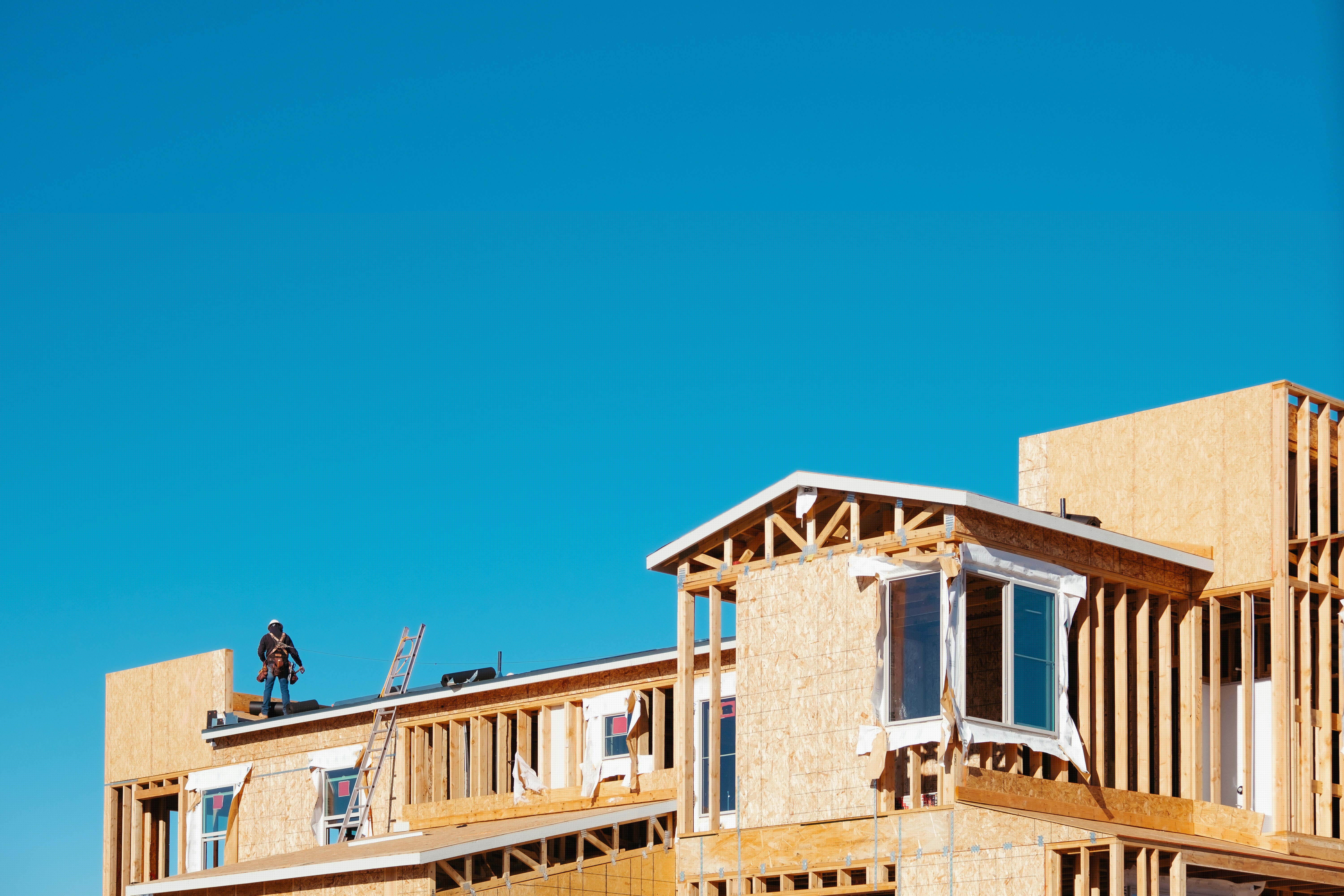 A giant new house being built. The wood is exposed and the sky is visible